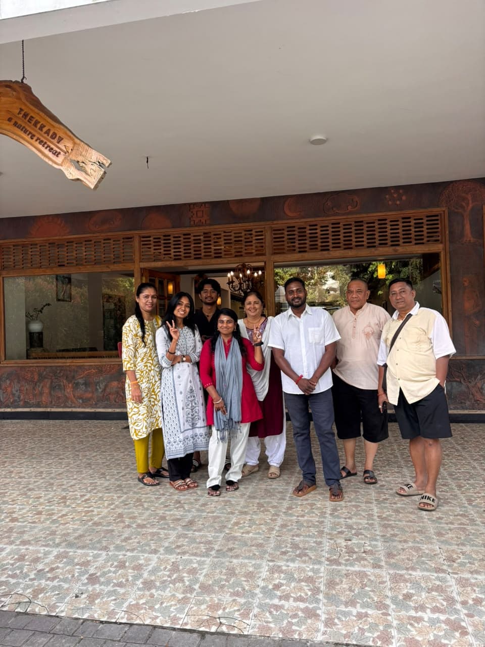 Family group of eight standing with their driver outside a nature retreat in Thekkady, Kerala